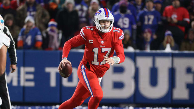 Bills quarterback Josh Allen rolls to his left as he looks downfield.
